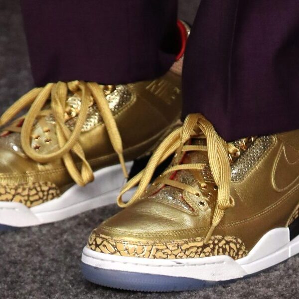 Gold-colored Air Jordans that have been custom-made for Spike Lee promote for…